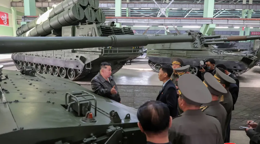 Kim Jong Un, yeri açıklanmayan bir mühimmat fabrikasını ziyaret ederken (AFP)