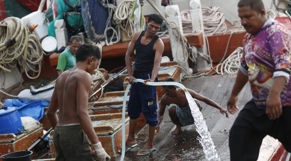 صيادون ينظفون قاربهم بعد عودتهم من البحر في ميناء لامبولو للصيد التقليدي في باندا آتشيه، إندونيسيا (إ.ب.أ)