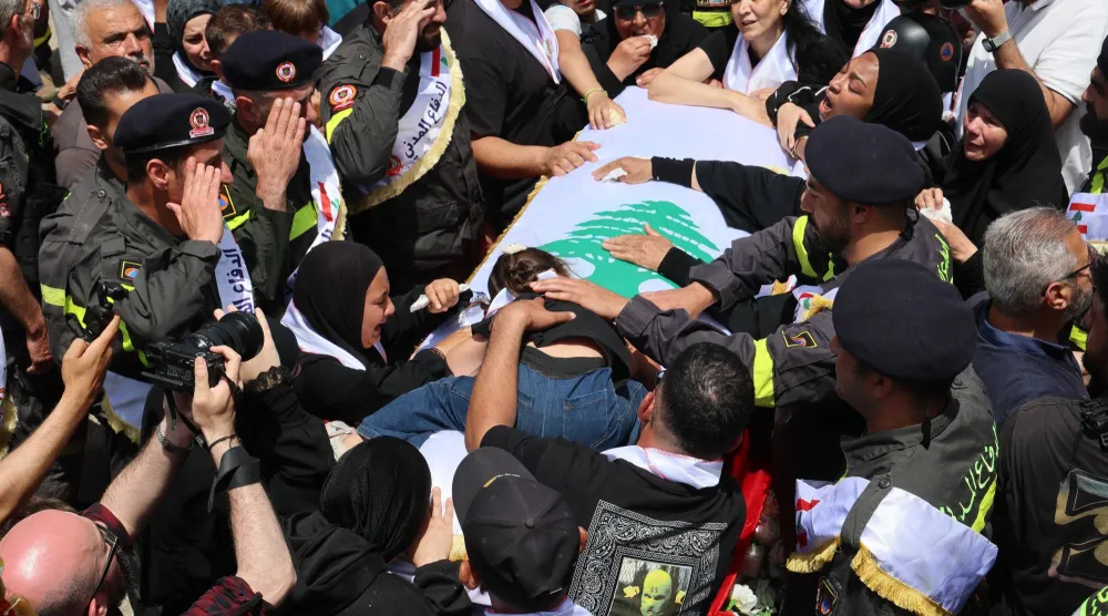مشيعون يشاركون في جنازة عنصرين من الدفاع المدني اللبناني قتلا في غارة إسرائيلية على مدينة النبطية في 13 مايو 2026 (رويترز)