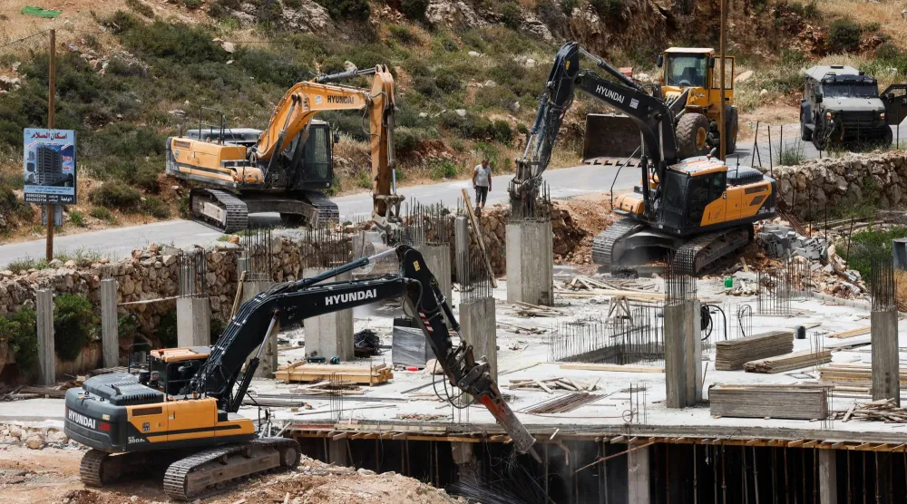 آليات إسرائيلية ثقيلة تهدم مبنى فلسطينياً قرب بيت لحم في الضفة الغربية المحتلة يوم الاثنين (رويترز)