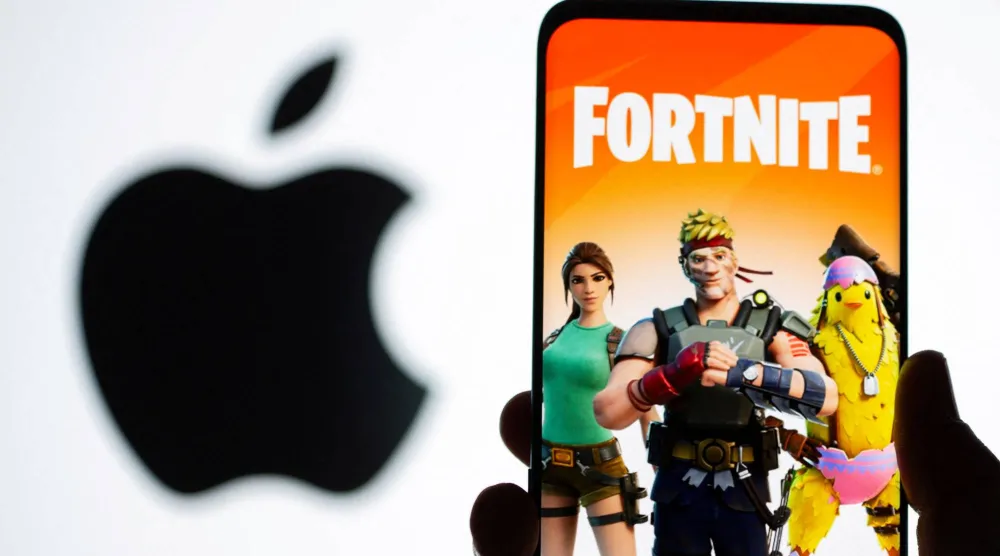 صورة ترتبط بلعبة «فورتنايت» تظهر على شاشة هاتف ذكي أمام شعار «أبل» (رويترز)