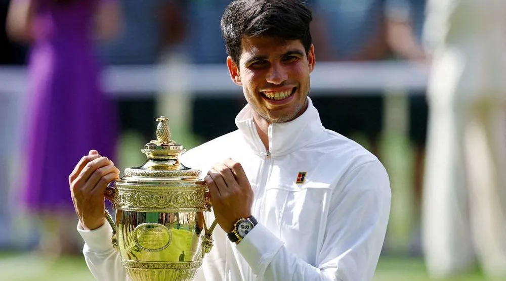 Tennis - Wimbledon - All England Lawn Tennis and Croquet Club, London, Britain - July 14, 2024 Spain's Carlos Alcaraz poses for a picture with the trophy after winning his men's singles final against Serbia's Novak Djokovic. (Reuters)