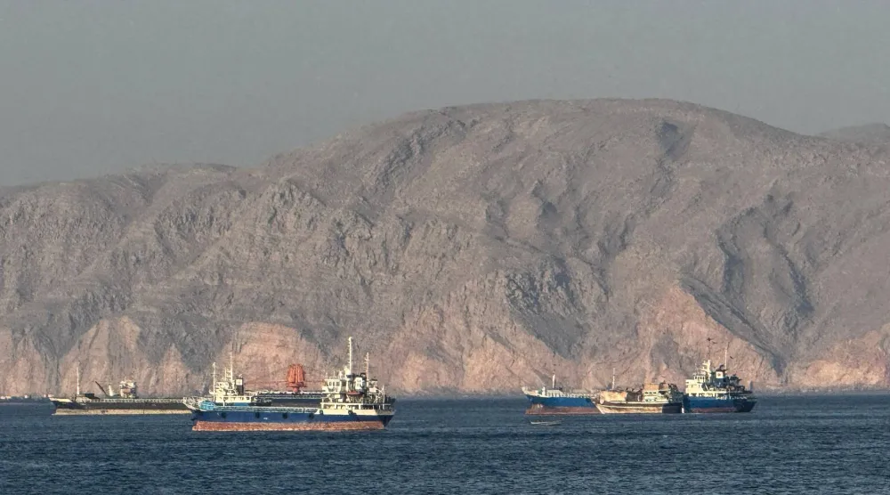سفن راسية في مضيق هرمز، قبالة مدينة خصب الساحلية في شبه جزيرة مسندم شمال عُمان (أ.ف.ب)