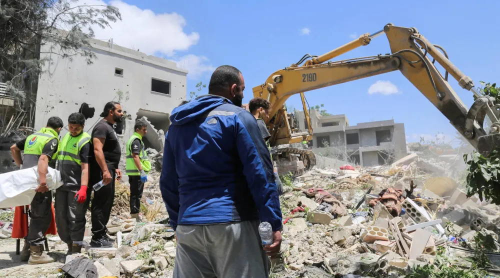 سكان يتجمعون في موقع استهداف إسرائيلي أسفر عن مقتل 12 شخصاً في بلدة دير قانون النهر جنوب لبنان (رويترز)