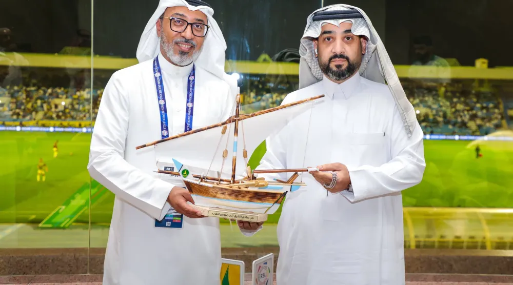 خالد الغامدي يتلقى هدية تذكارية من أحمد خريدة رئيس الخليج (موقع نادي الخليج)