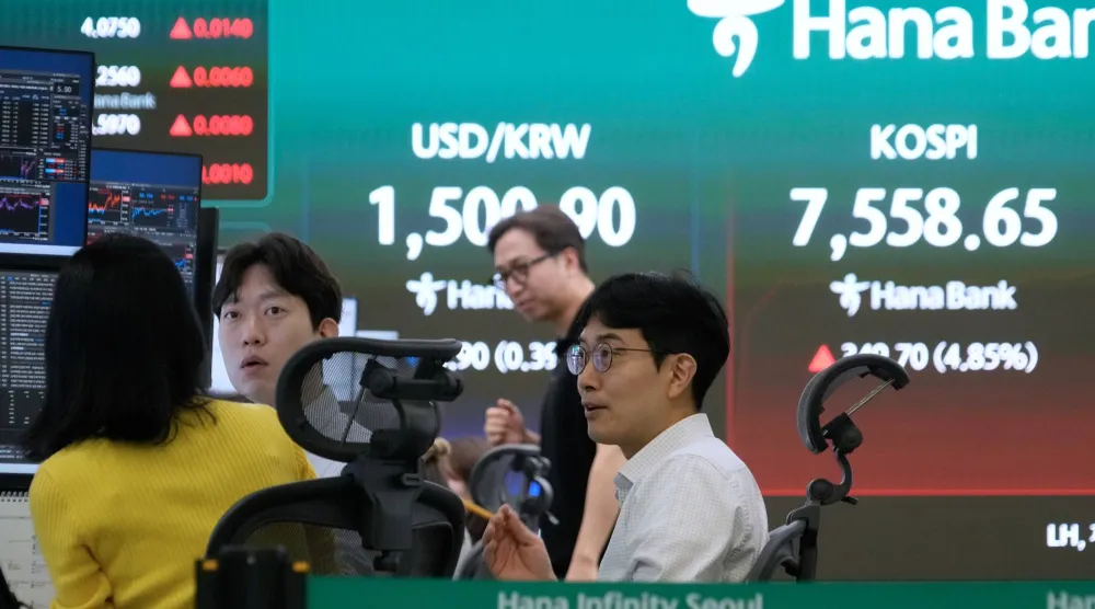 شاشة تعرض مؤشر «كوسبي» وسعر صرف العملات الأجنبية بين الدولار والوون الكوري الجنوبي في بنك هانا بسيول (أ.ب)