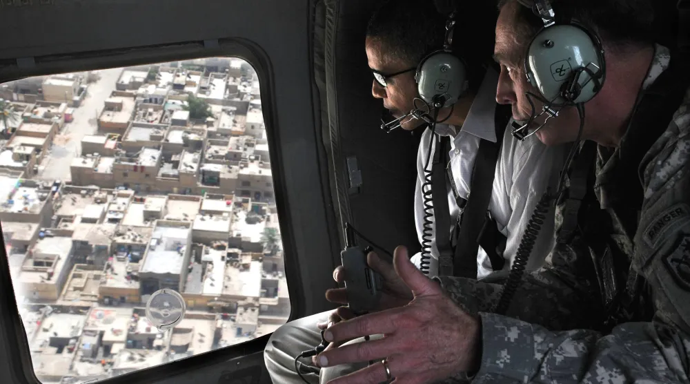 صورة نشرها «البنتاغون» عام 2008 لديفيد بترايوس وهو يشرح لباراك أوباما عندما كان سيناتوراً خطة لتأمين مدينة الصدر شرق بغداد خلال جولة فوق المدينة