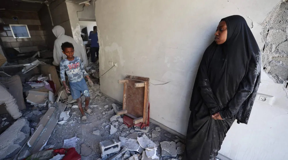 نازحون فلسطينيون يتفقدون الأضرار التي لحقت بأحد المنازل جراء غارة إسرائيلية في مخيم المغازي للاجئين وسط غزة يوم الخميس (أ.ف.ب)
