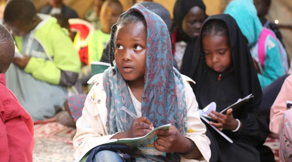 أطفال سودانيون نزحوا مع عائلاتهم إلى ليبيا يتلقون درساً في مدرسة للاجئين في تاجوراء شمال طرابلس (أرشيفية - أ.ب)