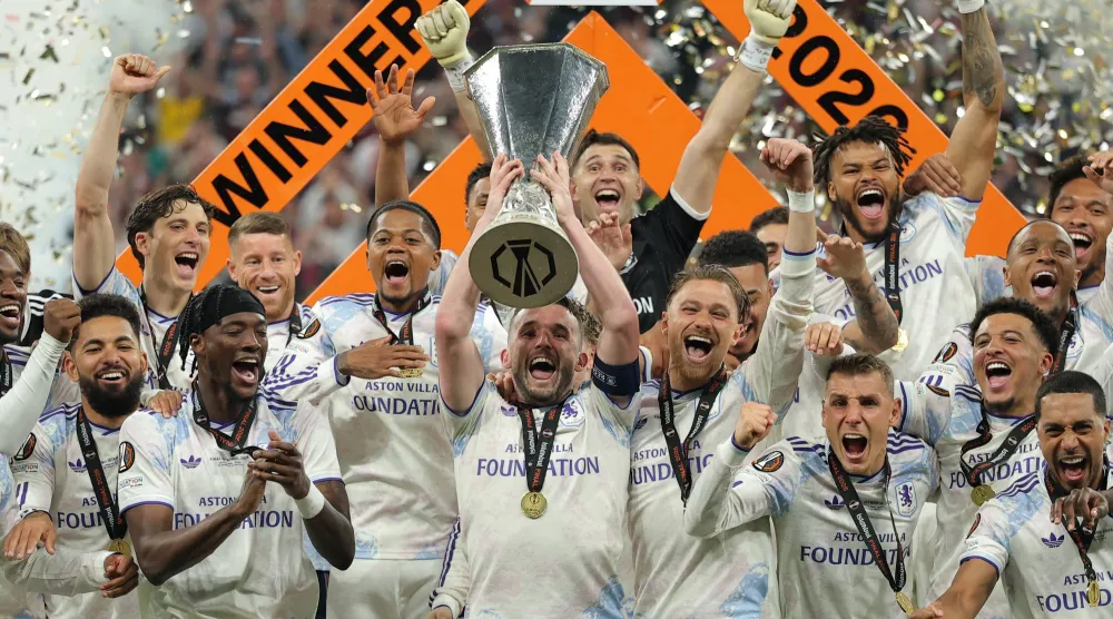 ماكجين قائد أستون فيلا يرفع كأس يوروبا ليغ محتفلاً بين زملائه على منصة التتويج (اب)