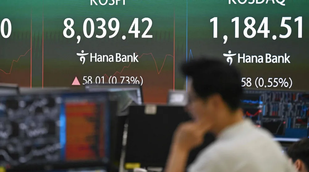 متداول عملات يراقب شاشة تُظهر تجاوز مؤشر «كوسبي» الكوري مستوى 8.000 نقطة في سيول (أ.ف.ب)
