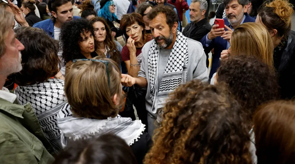 ناشط من أسطول الصمود العالمي يتحدث للصحافيين في فيوميتشينو بإيطاليا عقب الإفراج عنه من إسرائيل (رويترز)