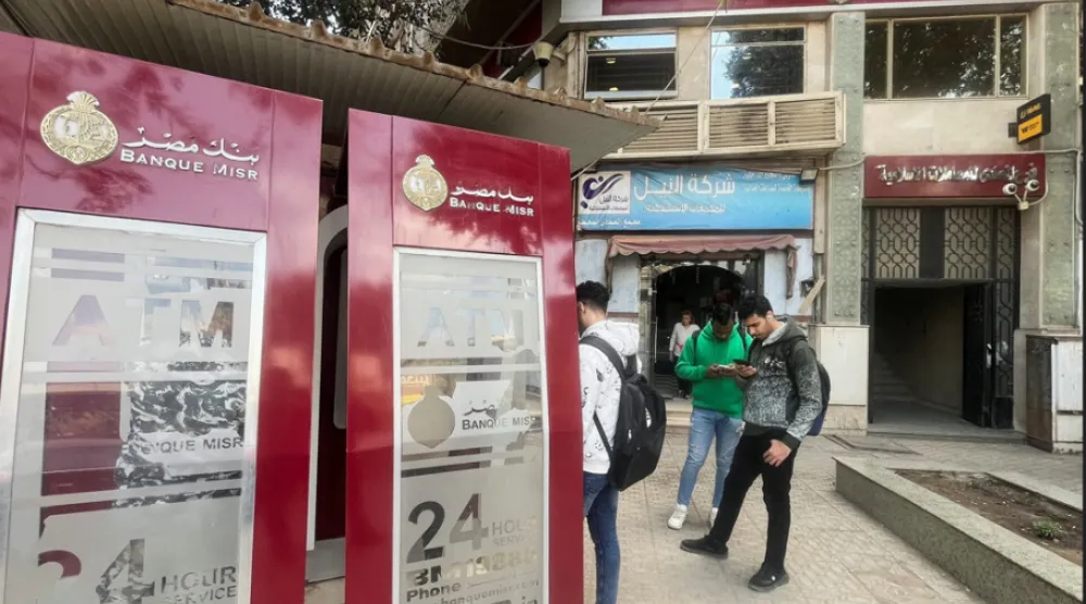 مواطنون مصريون أمام ماكينات الصرف التابعة لأحد البنوك الحكومية (رويترز)