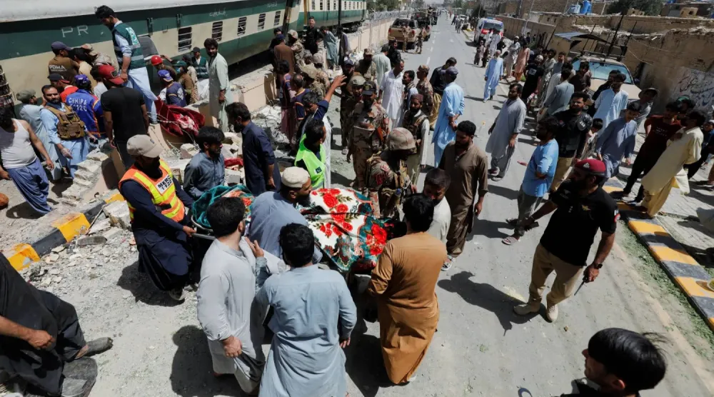 Pakistan’ın Ketta kentinde askerleri taşıyan bir trene düzenlenen bombalı saldırının ardından kurbanları arayan gönüllüler (AP)