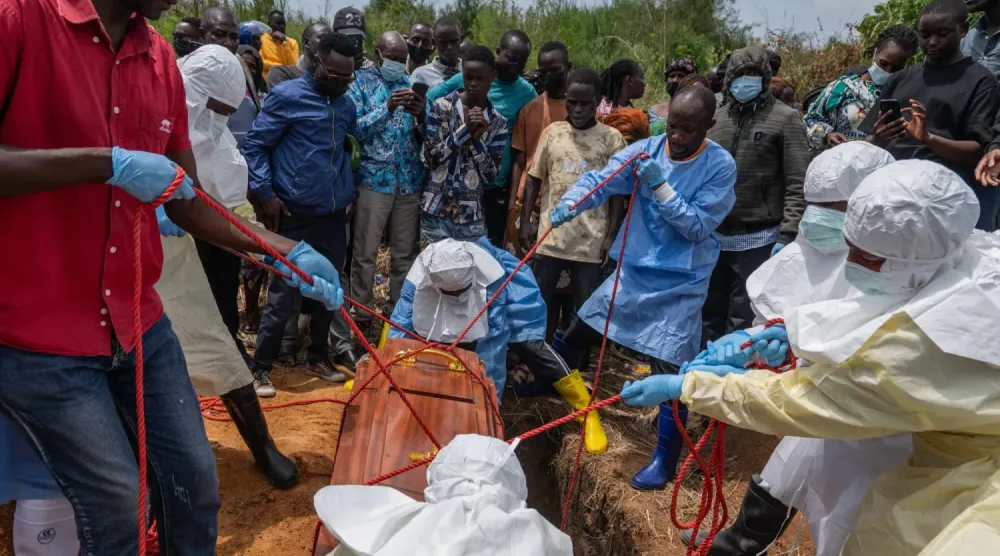(foto altı) Kızılhaç çalışanları 23 Mayıs’ta Ruambara’da Ebola kurbanlarını toprağa verdi. (AP)