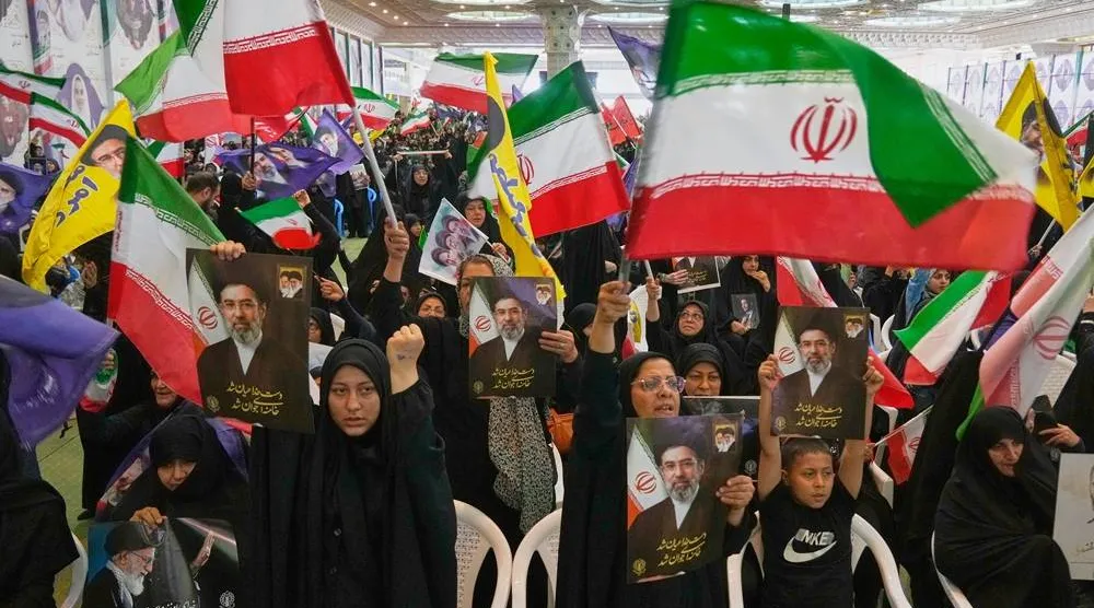 Government supporters hold Iranian flags and pictures of Iran's Supreme Leader, Mojtaba Khamenei, during a ceremony honoring the armed forces and those killed in the war with Israel and the US in Tehran, Iran, Sunday, May 24, 2026. (AP) 