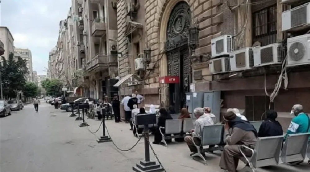 مصريون أمام أحد بنوك وسط القاهرة لصرف معاشاتهم (أرشيفية - صفحة وزارة التضامن الاجتماعي المصرية على «فيسبوك»)