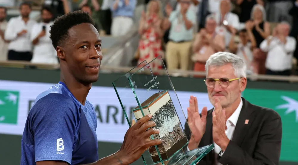 France's Gael Monfils (L) poses with a trophy next to French Tennis Federation's President Gilles Moretton (R) during a ceremony honoring his career on day 2 of the French Open tennis tournament on Court Philippe-Chatrier at the Roland-Garros Complex in Paris on May 25, 2026. (Photo by ALAIN JOCARD / AFP)