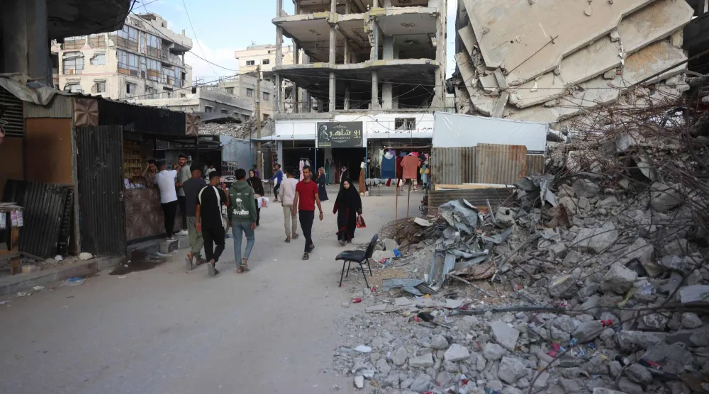 فلسطينيون يشقون طريقهم عبر أنقاض مبانٍ دمرتها غارات إسرائيلية... في خان يونس جنوب قطاع غزة 26 مايو 2026 (أ.ف.ب)