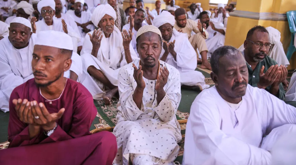 مصلون يستمعون لخطبة صلاة عيد الأضحى بأحد مساجد الخرطوم (أ.ب)