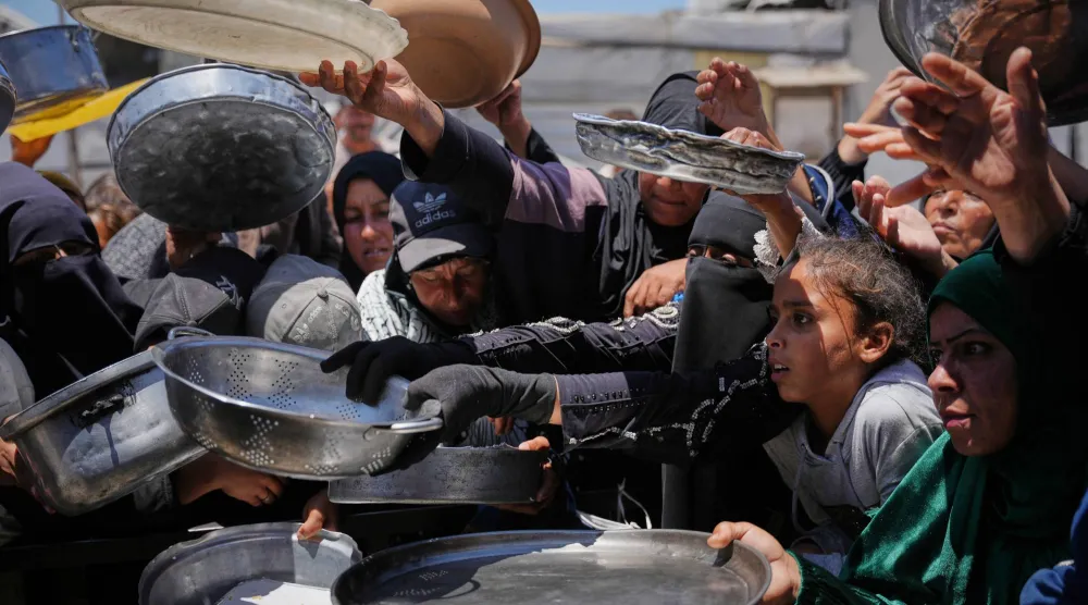 فلسطينيون يزاحمون للحصول على طعام في خان يونس في أول أيام العيد (أ.ب)