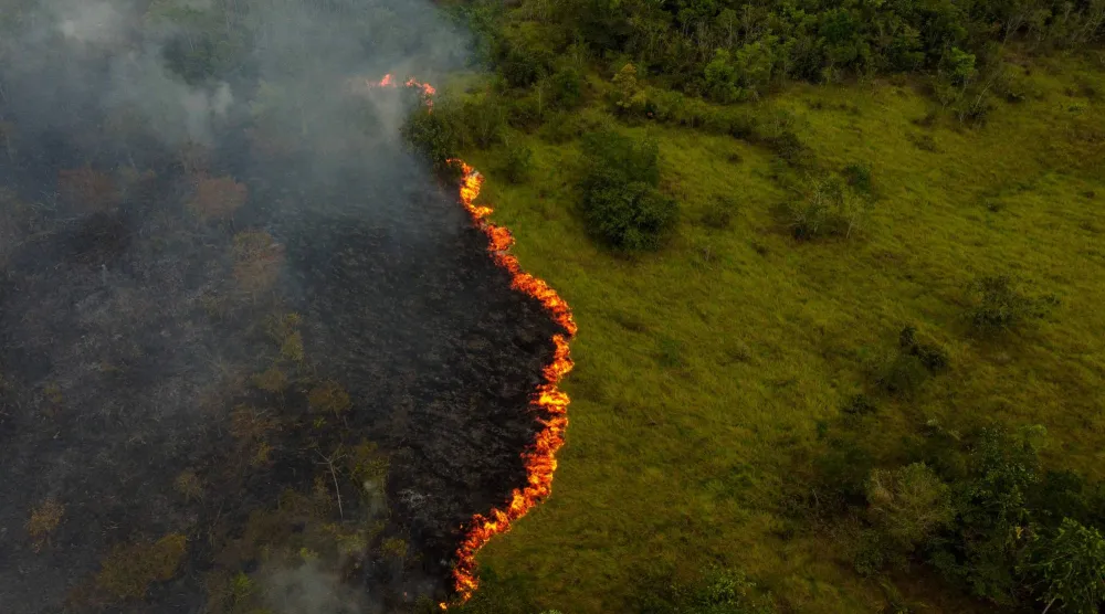 (FILES) Smoke from illegal fires lit by farmers rises in Manaquiri, Amazonas state, on September 6, 2023. (Photo by MICHAEL DANTAS / AFP)