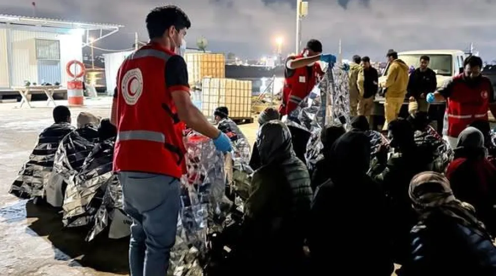 متطوعون من الهلال الأحمر الليبي يقدمون مساعدات إنسانية لمهاجرين غير نظاميين في ساحل مدينة طبرق الليبية (الصفحة الرسمية للهلال الأحمر)