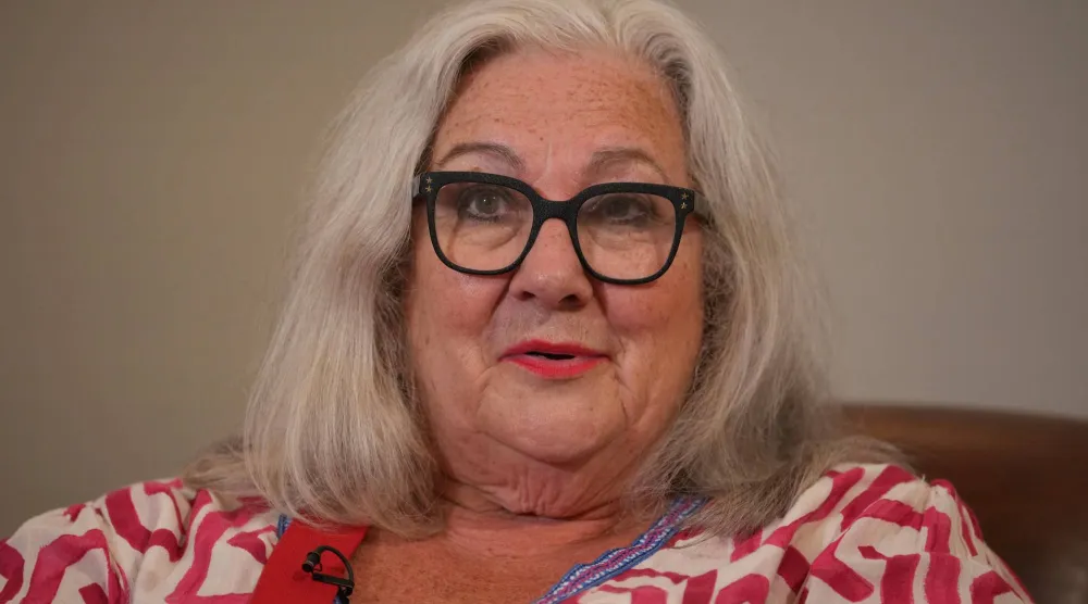 Sue Tilley, a model for British painter Lucian Freud, speaks in front of Freud's painting of her, titled "Sleeping by the Lion Carpet" during an interview in Sotheby's auction house in London, Thursday, May 28, 2026. (AP)