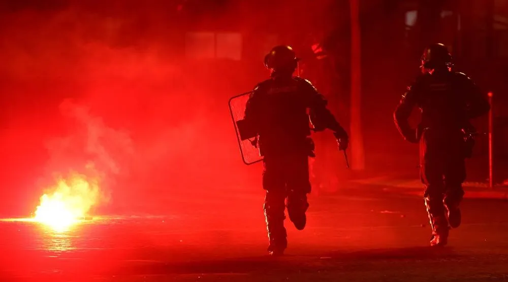 Football - UEFA Champions League - Paris St Germain fans celebrate winning the UEFA Champions League - Paris, France - May 31, 2026 Police officers protect themselves from a flare after Paris St Germain won the UEFA Champions League. (Reuters)