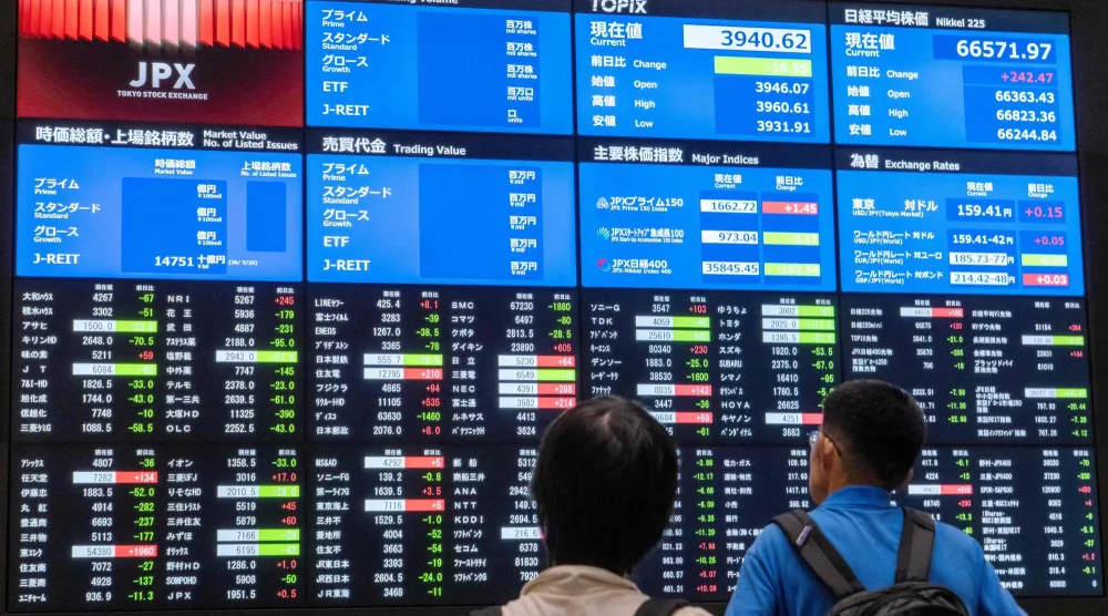 متداولون يتابعون حركة الأسهم والمؤشرات الاقتصادية في بورصة طوكيو بالعاصمة اليابانية (أ.ف.ب)