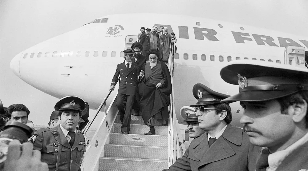الخميني ينزل من طائرة تابعة لـ«إير فرانس» أقلّته إلى طهران في الأول من فبراير (شباط) 1979 بعد 15 عاماً في المنفى (غيتي)