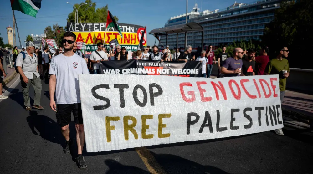 متظاهرون مؤيدون للفلسطينيين ضد السياح الإسرائيليين بعد وصولهم إلى أثينا (أ.ف.ب)