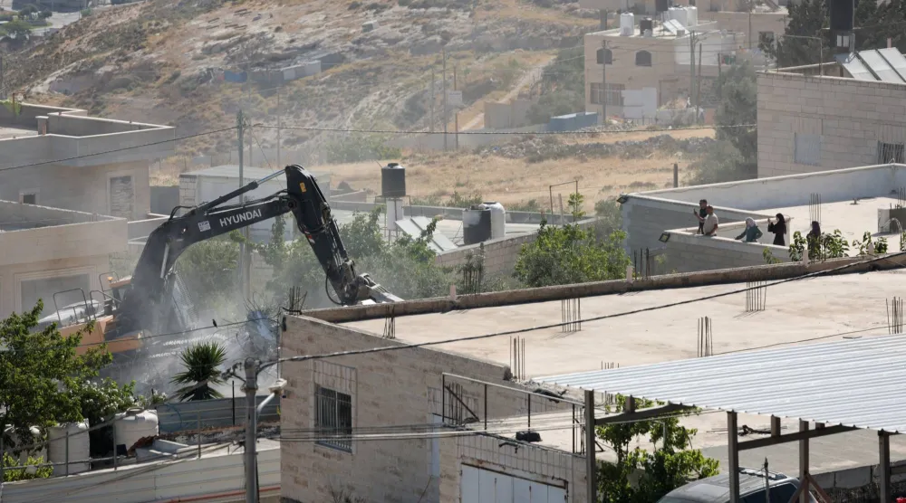 حفارة إسرائيلية تهدم مبنى للفلسطينيين في الضفة الغربية (رويترز)