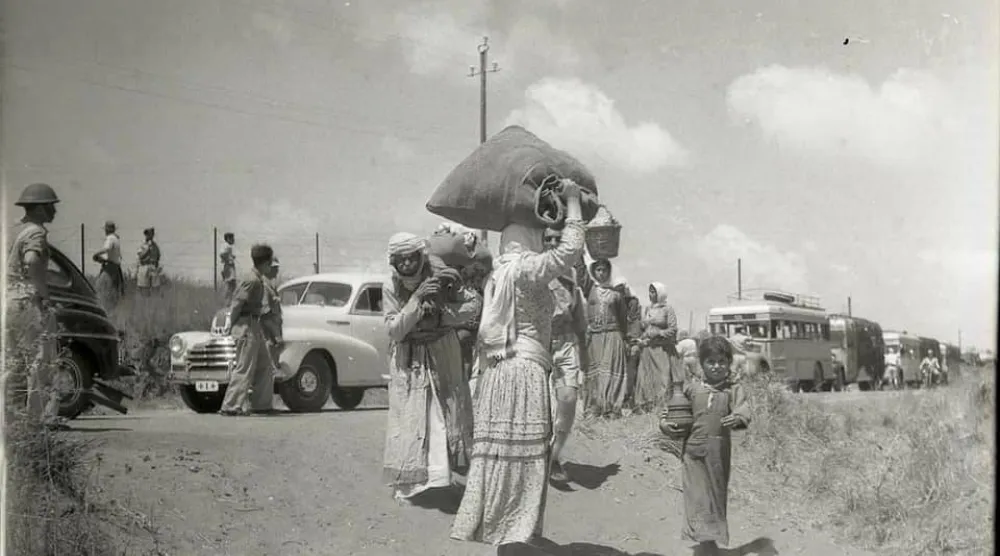 فلسطينيون معظمهم من النساء والأطفال في طريقهم للخروج من منازلهم بقرية الطنطورة في مايو 1948 بعد جرائم «تطهير عرقي» ارتكبتها عصابات صهيونية بحق رجال القرية (موقع فلسطين في الذاكرة)