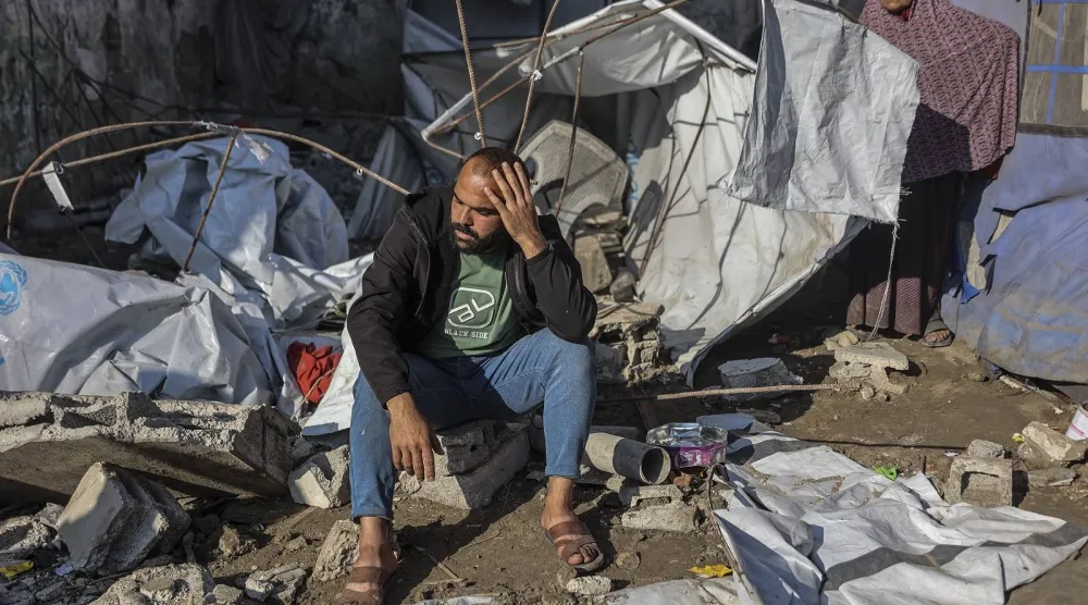 فلسطيني يجلس في موقع غارة عسكرية إسرائيلية استهدفت مباني وخياماً تؤوي عائلات نازحة في مدينة غزة (أ.ف.ب)