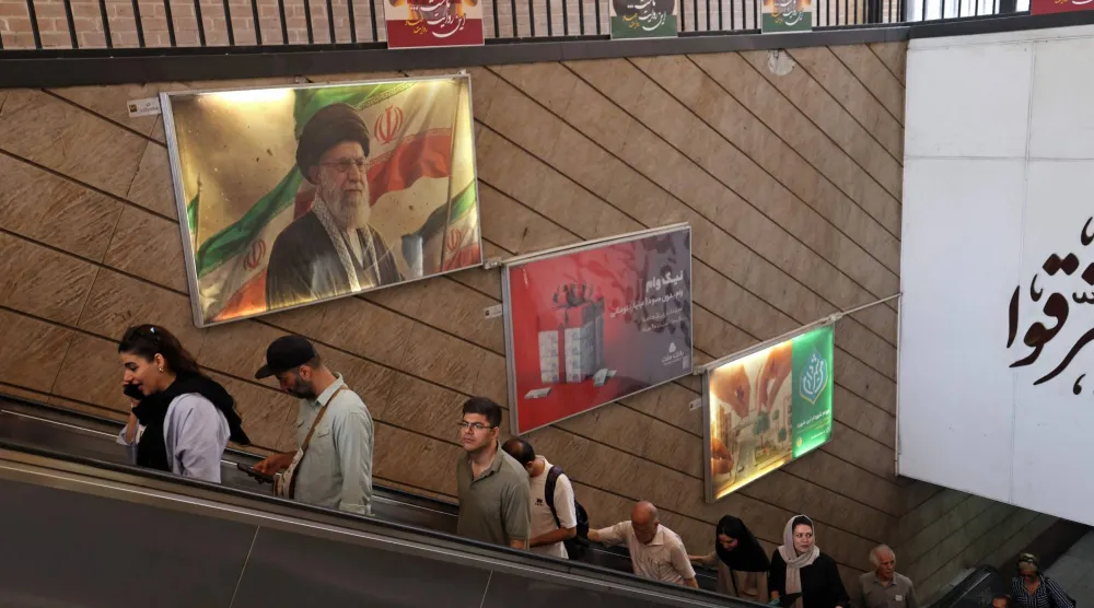أشخاص يغادرون محطة مترو في طهران تحت صورة المرشد علي خامنئي 3 يونيو 2026 (أ.ف.ب)