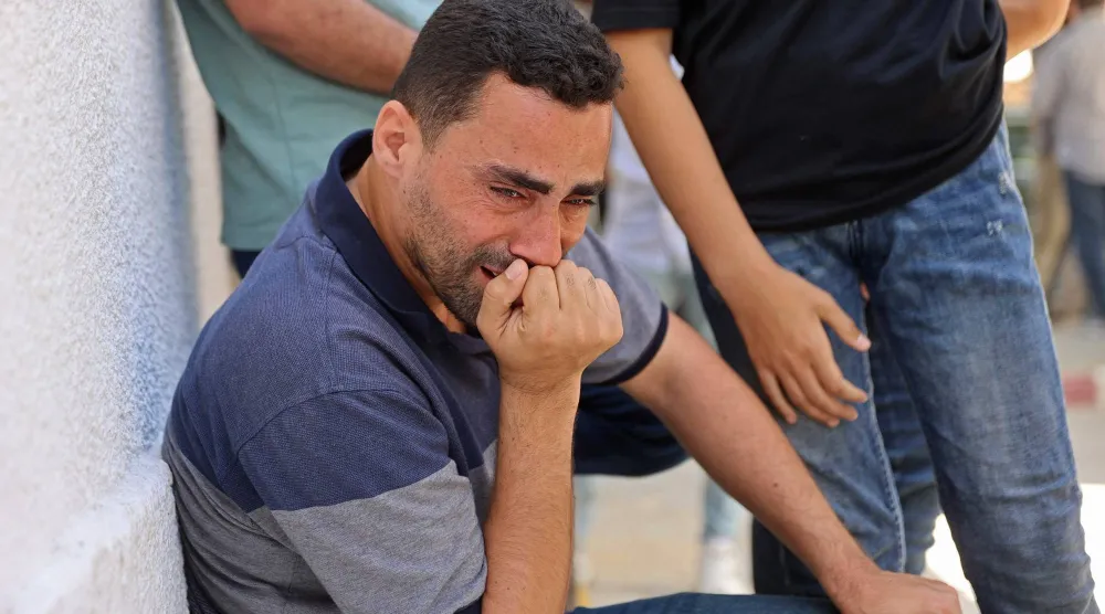 فلسطيني يبكي خلال تشييع ضحايا غارات إسرائيلية من مستشفى الشفاء في مدينة غزة الخميس (أ.ف.ب)

