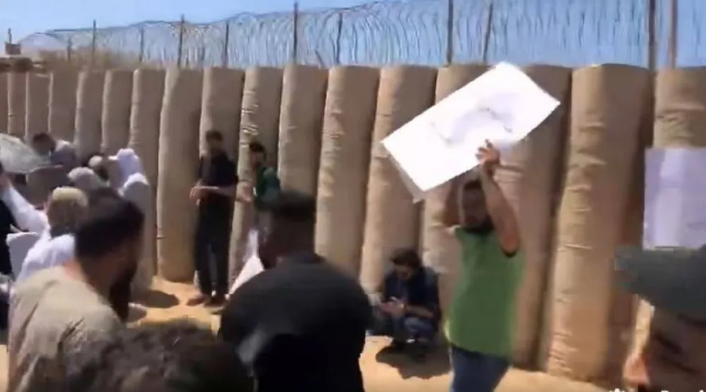 جانب من المحتجين بعد تجاوزهم الأسوار الخارجية لمقر البعثة الأممية في جنزور غرب ليبيا (من مقطع فيديو)