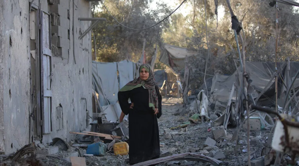 فلسطينية في مكان قصفته إسرائيل بعد تحذير سكان بإخلاء منزلهم في بلدة الزوايدة وسط قطاع غزة (أ.ف.ب)