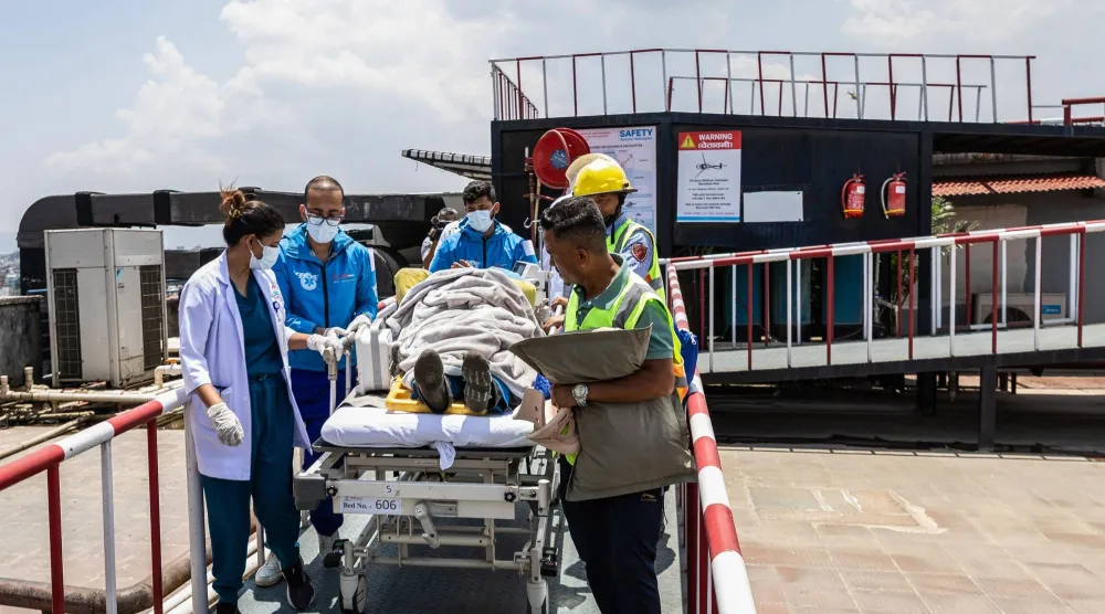 Medics and rescuers carry mountaineer Dawa Sherpa upon his arrival at the HAMS Hospital in Kathmandu on June 4, 2026. (Photo by PRABIN RANABHAT / AFP)