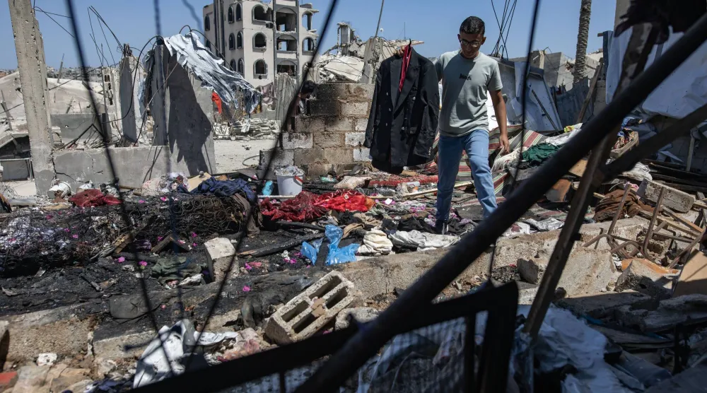 فلسطيني يحمل جاكيت الشاب مهند فروانة الذي قتلته غارة إسرائيلية بينما كان يتجهز لحفل زفافه ظهر اليوم في خان يونس جنوب قطاع غزة (إ.ب.أ)