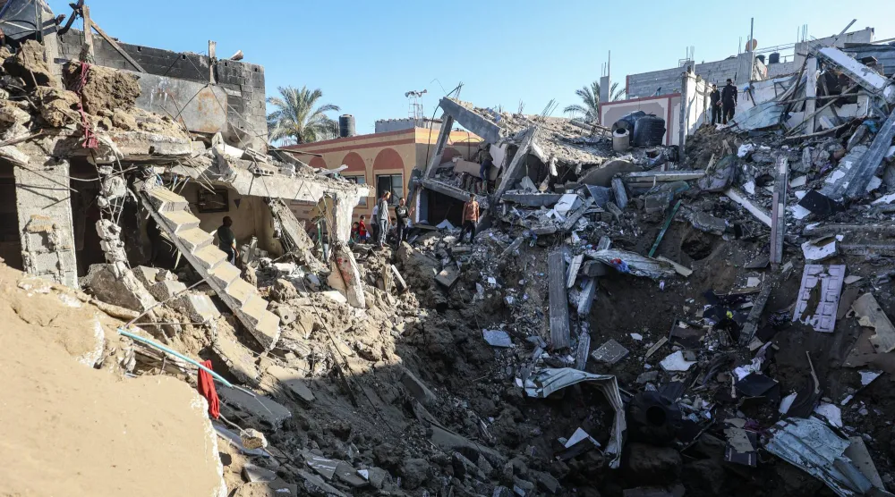 فلسطينيون يعاينون ركام مبنى استهدفته غارة جوية إسرائيلية في دير البلح وسط قطاع غزة 29 مايو 2026 (د.ب.أ)