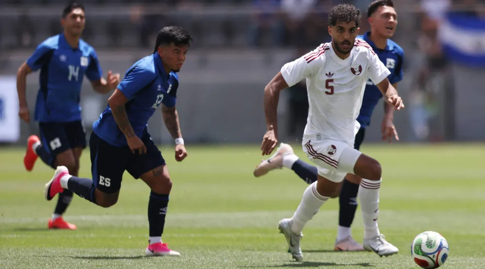 جاسم جابر لاعب منتخب قطر يحاول لعب الكرة تحت ضغط مارسيلو دياز لاعب السلفادور (أ.ف.ب)