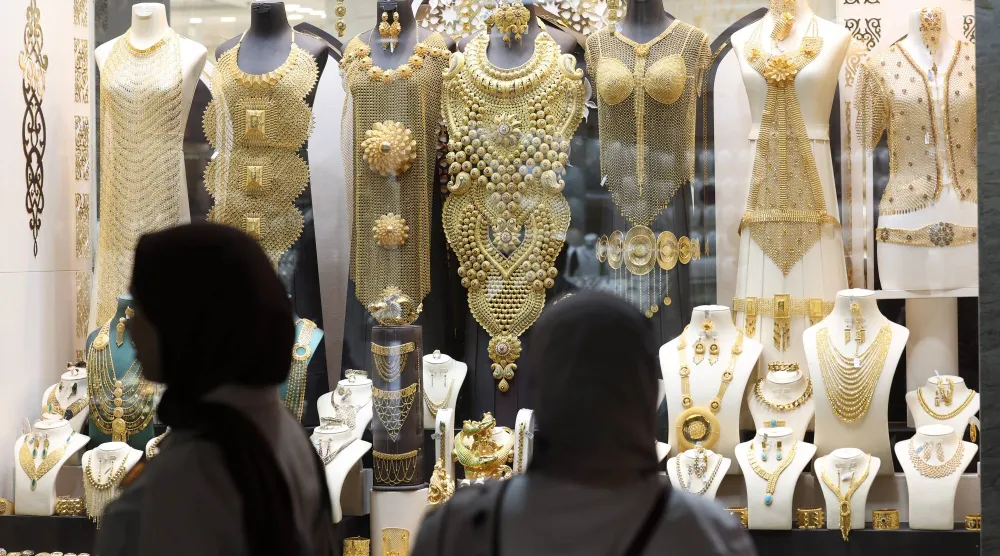 سيدتان تتفقدان قطع الذهب في محل مجوهرات داخل سوق الذهب في دبي (إ.ب.أ)