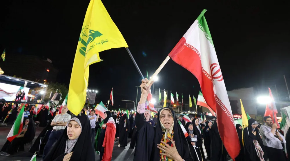 متظاهرون إيرانيون مؤيدون للحكومة يرفعون أعلام إيران و«حزب الله» بعد غارات إسرائيلية على الضاحية الجنوبية لبيروت في طهران في 7 يونيو 2026 (أ.ف.ب)