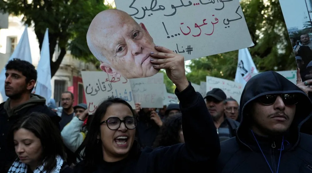 نشطاء ومعارضون سياسيون يشاركون في مظاهرة بالعاصمة تونس (رويترز)