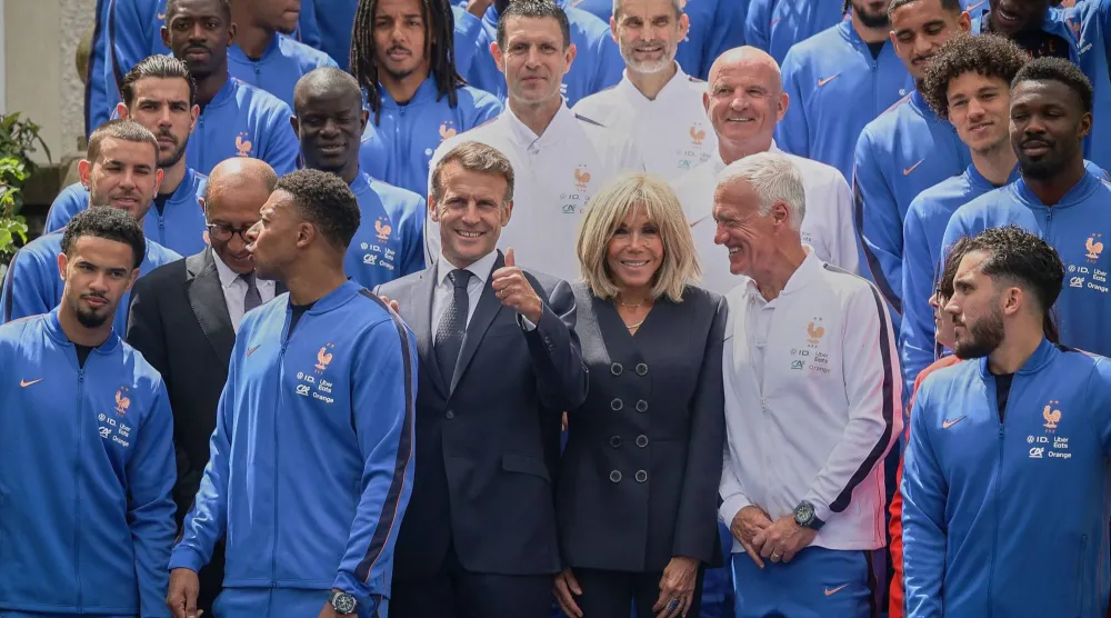 الرئيس الفرنسي إيمانويل ماكرون وزوجته بريجيت ماكرون يتوسطان المنتخب الفرنسي لكرة القدم خلال زيارة لملاعب تدريب المنتخب الوطني في كليرفونتين أون إيفلين جنوب غربي باريس 2 يونيو 2026 (أ.ف.ب)