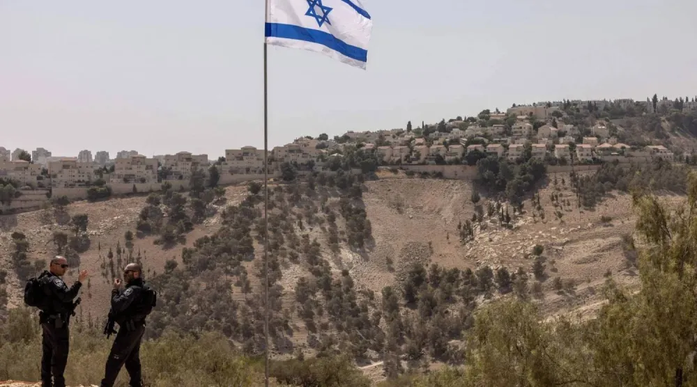 شرطيان إسرائيليان يقفان في منطقة «إي 1» قرب مستوطنة «معاليه أدوميم» خارج القدس في الضفة الغربية (أرشيفية - أ.ف.ب)