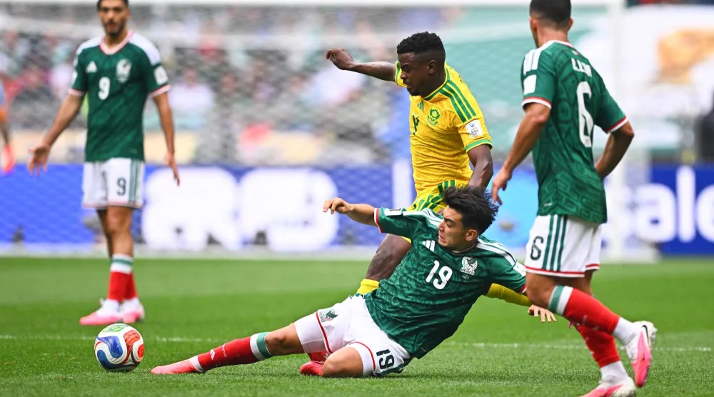 تنافس المكسيكي جيلبرتو مورا ولاعب منتخب جنوب أفريقيا تيبوهو موكوينا على الكرة (د.ب.أ)