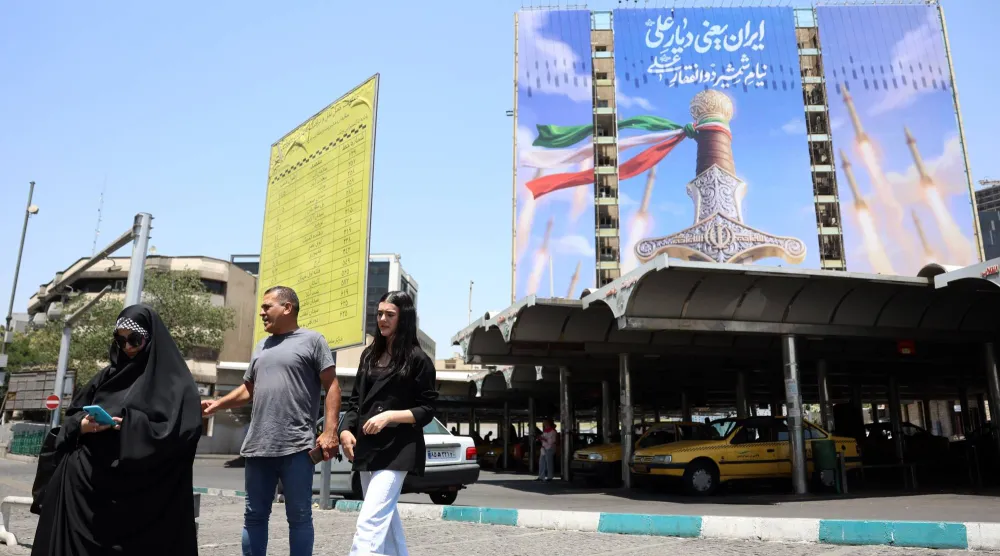 إيرانيون يمرون أمام لوحة إعلانية سياسية في طهران - إيران 11 يونيو 2026 (إ.ب.أ)

